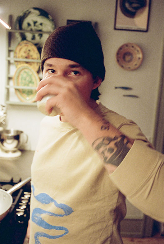 Freddie der kigger ind i kameraet, mens han tager en tår af sine kaffe.