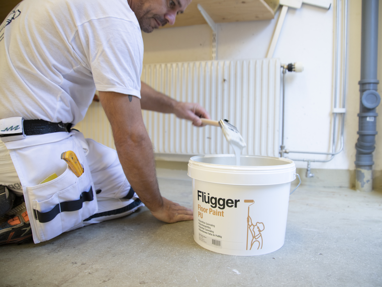 Professionel maler maler gulv med pensel med Floor Paing PU i hvid farve.