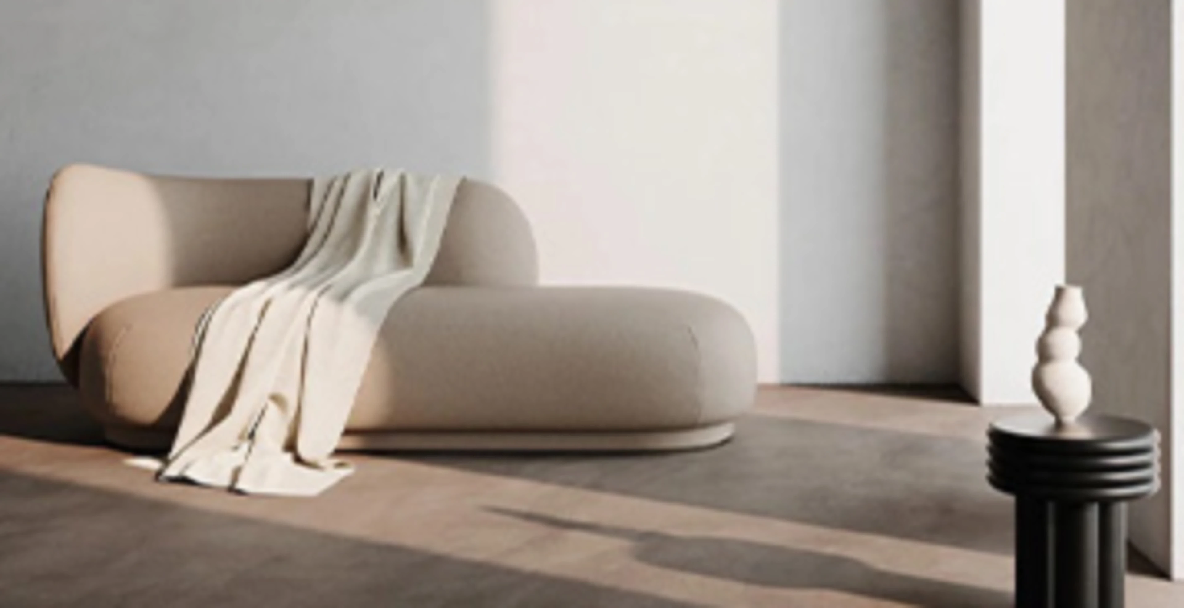 Stue med en beige sofa, hvite vegger og lyst tregulv.