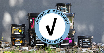 Tilfredshedsgaranti for dækkeevne-logo placeret foran Flügger malingsprodukter opstillet udendørs.