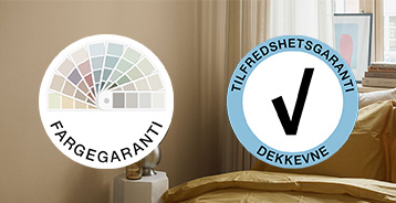 Farvegaranti- og Tilfredshedsgaranti for dækkeevne-logoer vist foran et interiør med beige væg, grønt vinduesparti og vase med blomster.