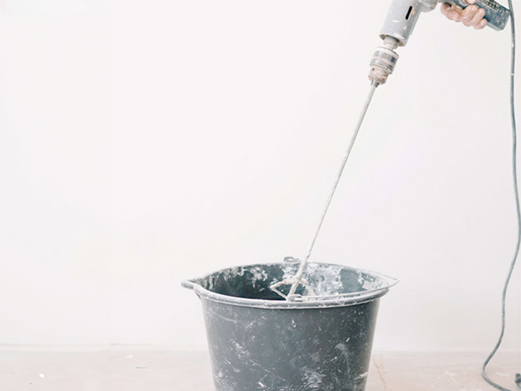 Mixing epoxy paint with a stirrer before application.
