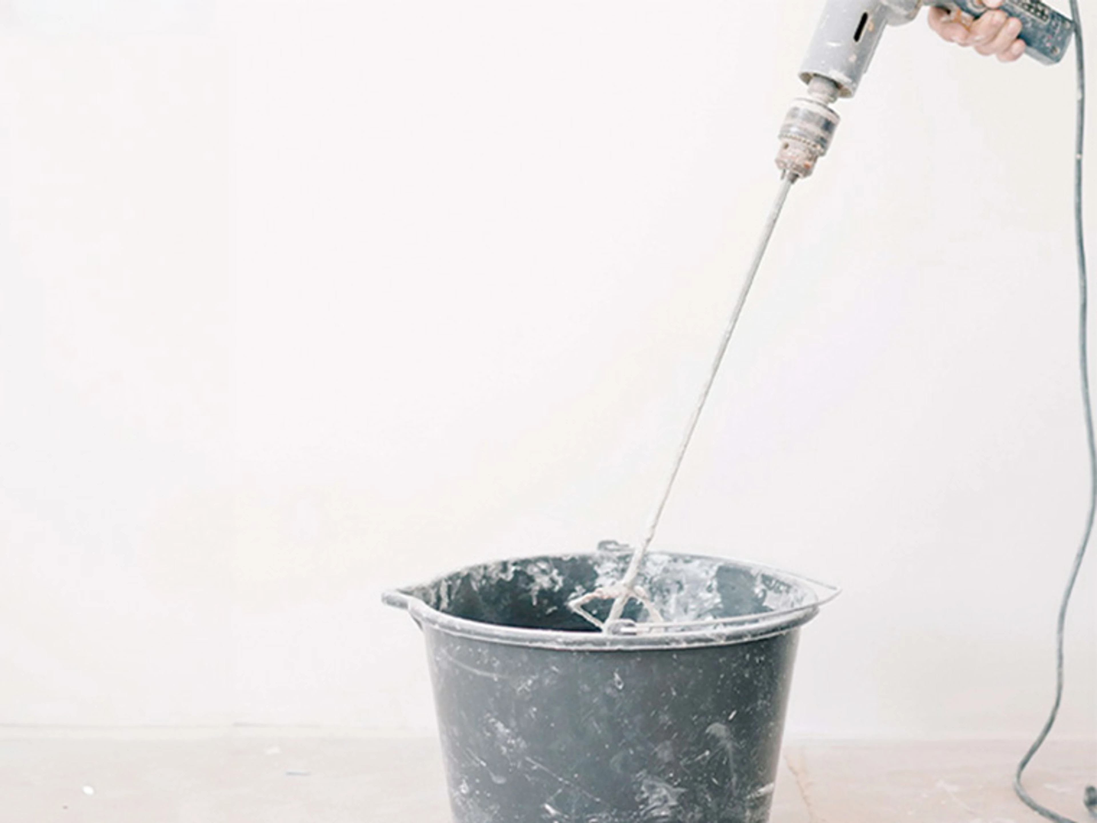 Mixing epoxy paint with a stirrer before application.
