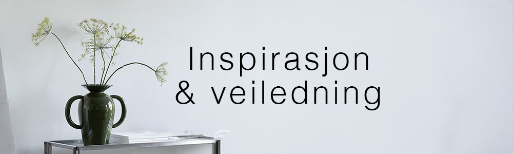 Vase med grønne blomster på et sidebord foran en lys væg med teksten "Inspirasjon & veiledning".
