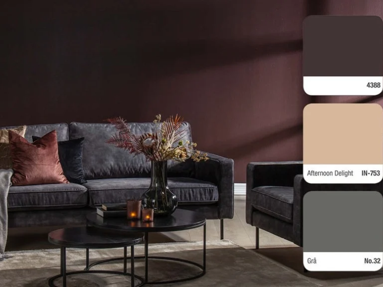 Living room with dark burgundy walls, a dark grey sofa and armchair, round black coffee tables and a vase with dried flowers, with three colour swatches on the right: 4388, Afternoon Delight IN-753 and Grå No.32.