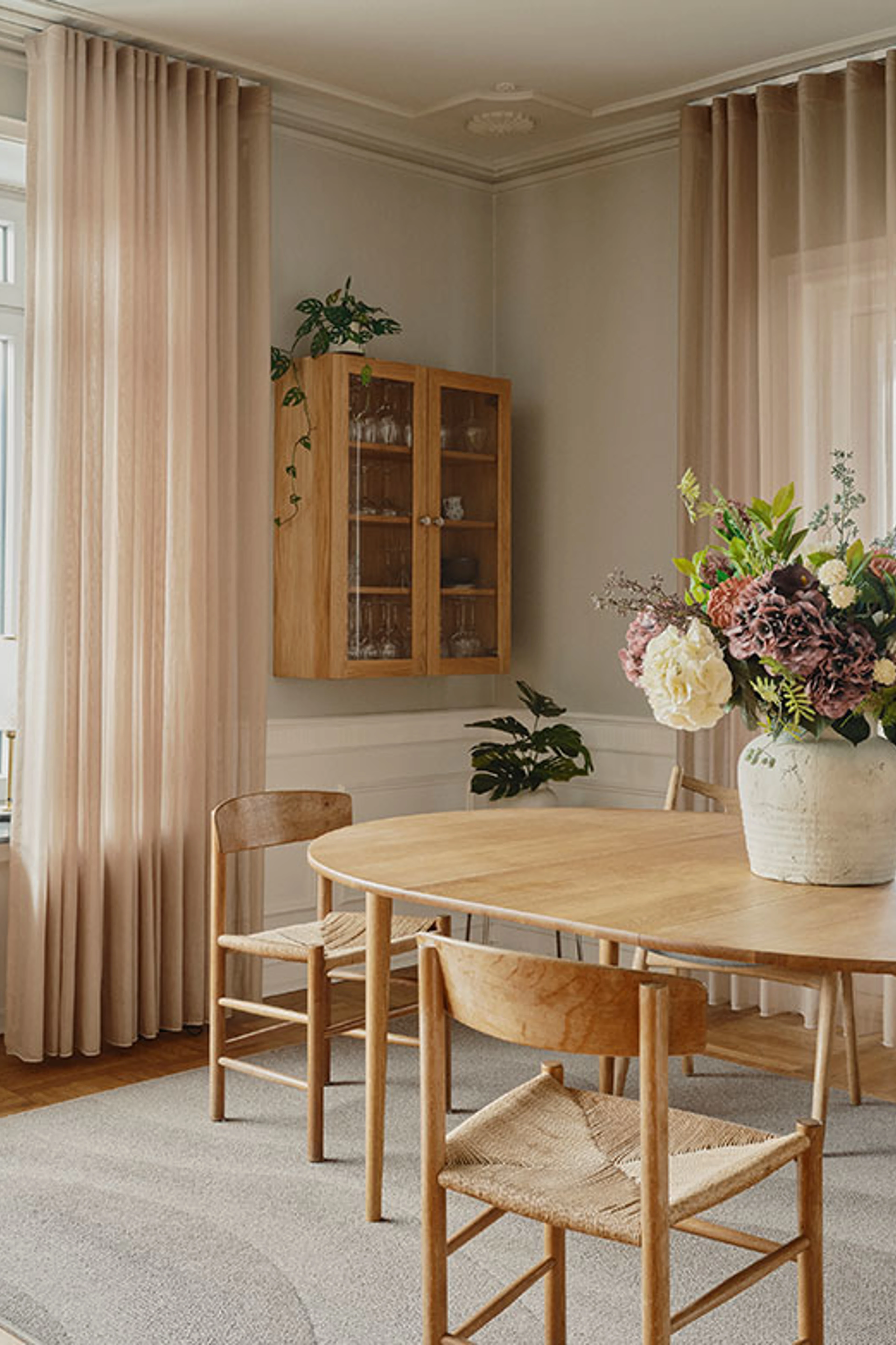 Spisestuen med blomster på bordet, med farven Cotton på væggene.