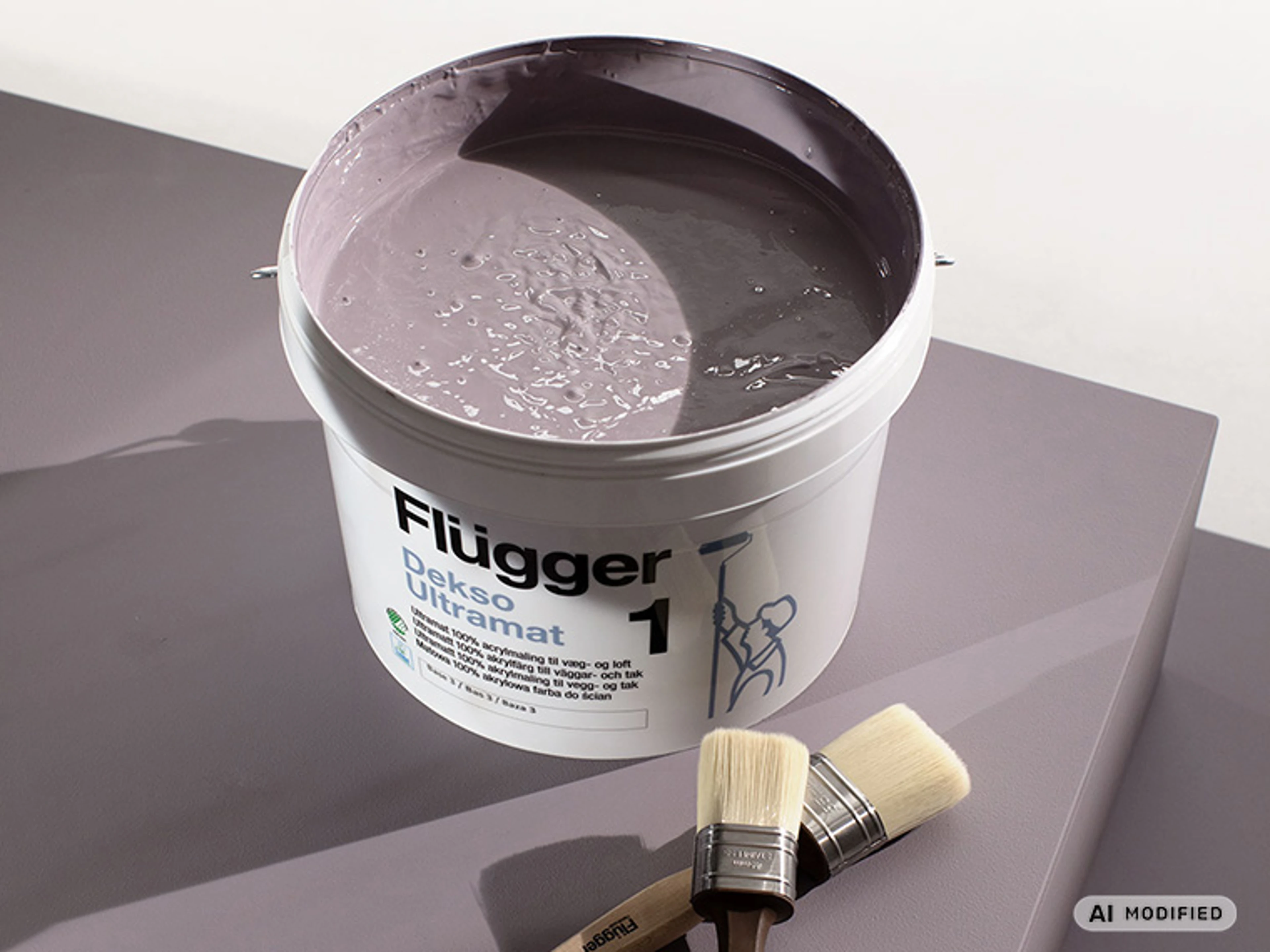 Spand med Flügger Dekso Ultramat maling tonet i farven Kind Purple (FL8057) står på en malet overflade sammen med to pensler. Malingens lilla nuance er synlig i den åbne spand.