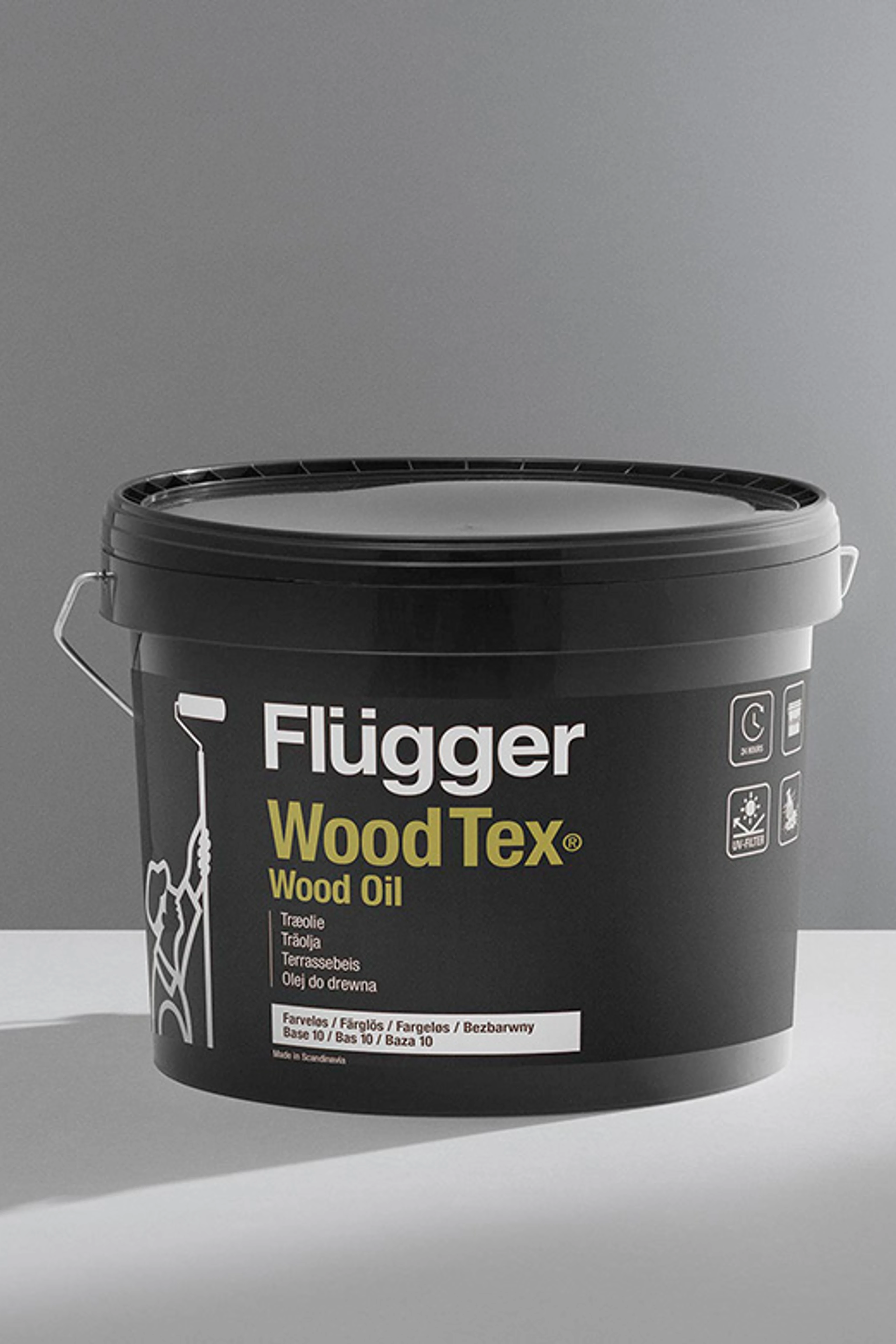 Spand med Flügger Wood Tex Wood Oil træolie foran en neutral grå baggrund.