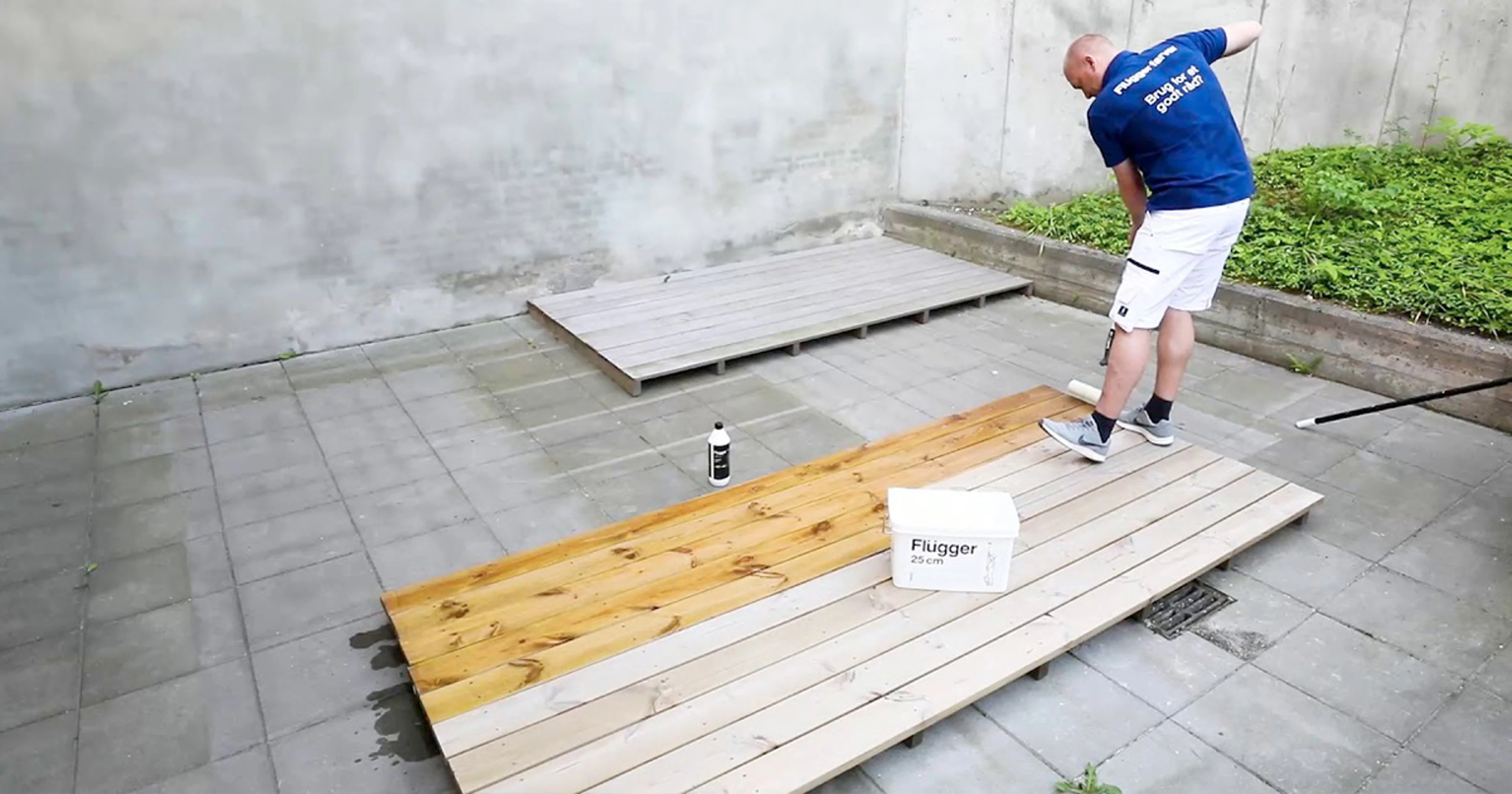 Person påfører treolje på terrassebord og viser forskjellen mellom ubehandlet og behandlet tre.