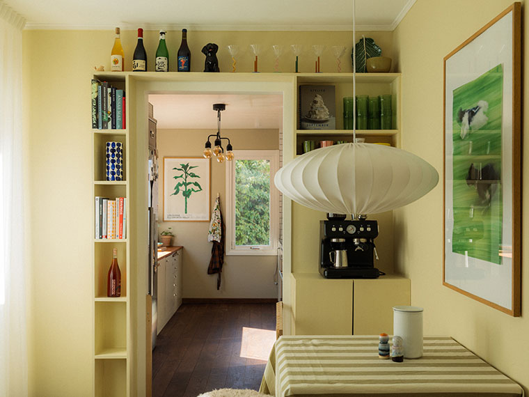 Pale yellow dining room with built-in shelves around a doorway.