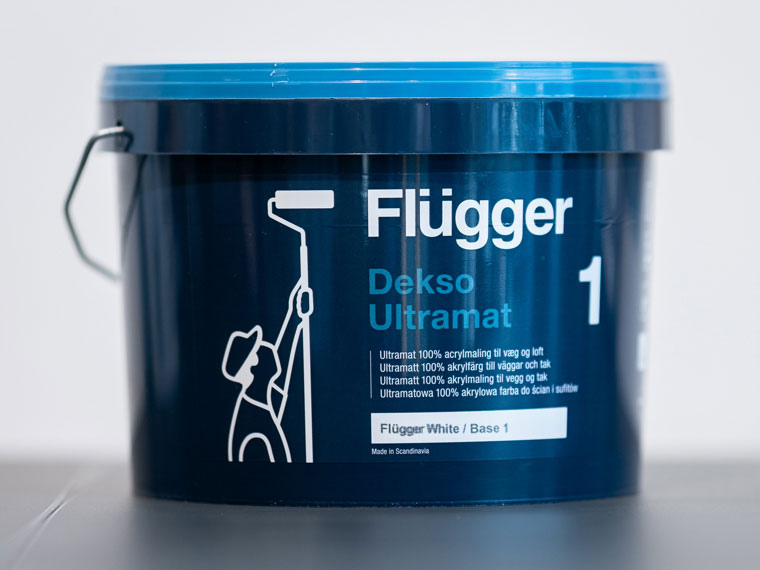 En mørkeblå spann med Flügger Dekso Ultramatt vegg- og takmaling, med en logo av en person som maler med rulle.