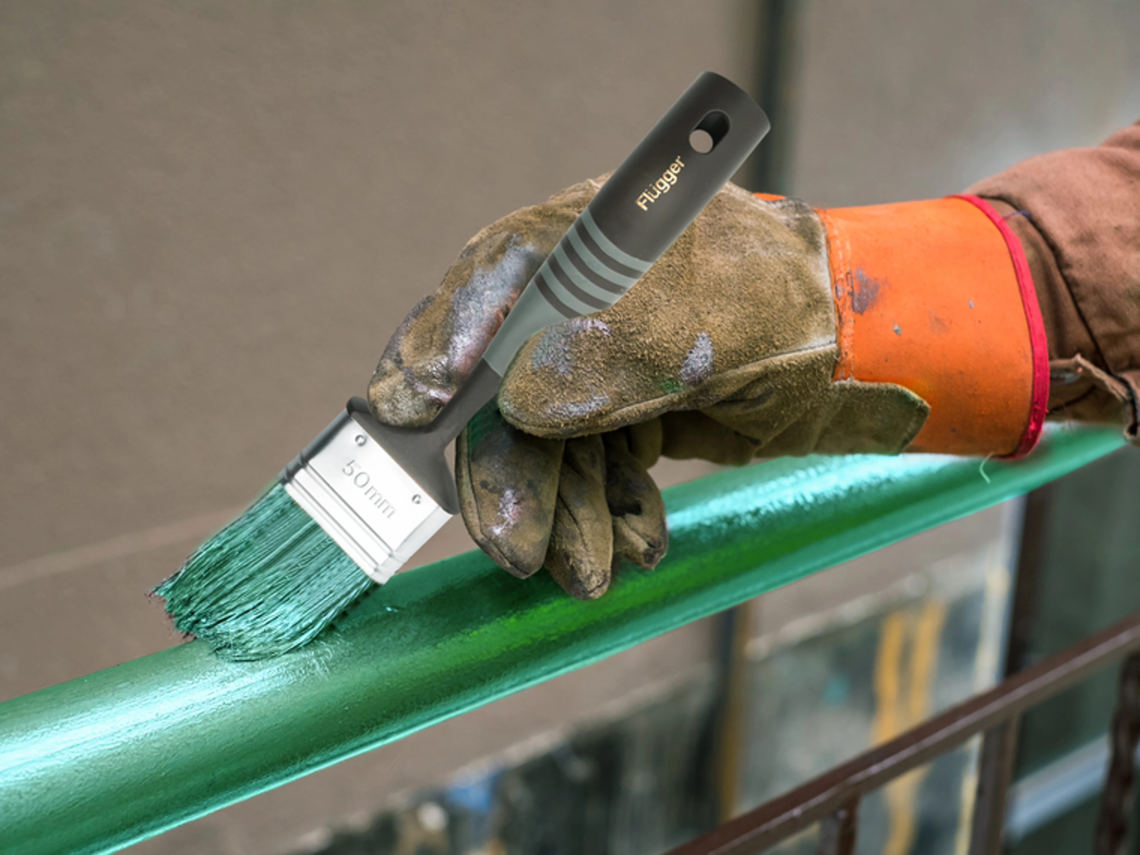 Målning av en balkong med grön metallfärg med en Flügger-pensel.