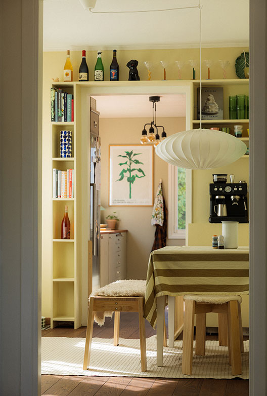 Dining room with pale yellow walls and built-in bookcases around the door to the kitchen.