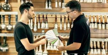 Flugger butiksassistent rådgiver en kunde om farver i butikken.