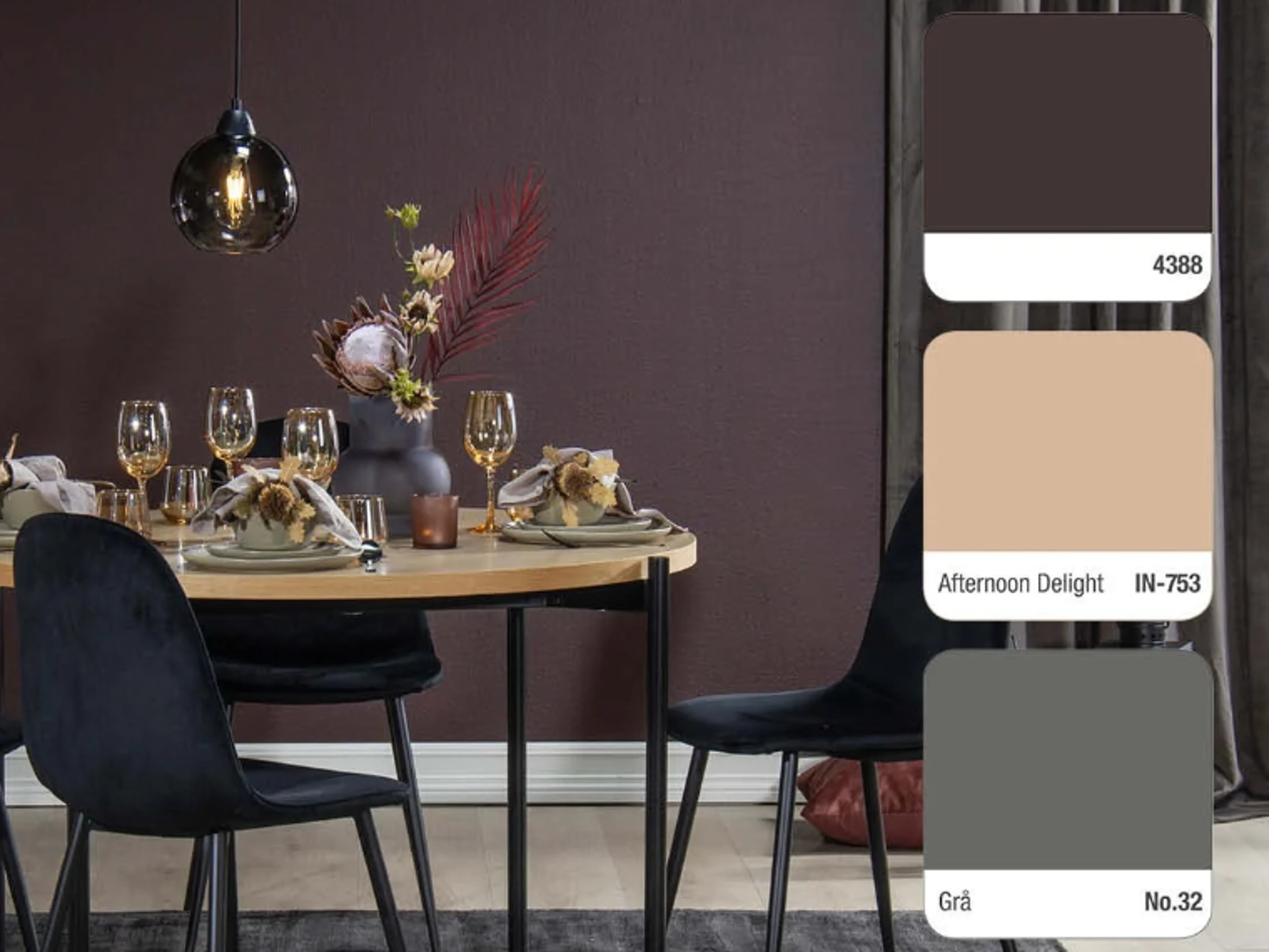 Dining area with dark burgundy walls, a round wooden table set with golden glasses and a floral arrangement, black velvet chairs and a glass pendant lamp, with three colour swatches on the right: 4388, Afternoon Delight IN-753 and Grå No.32.